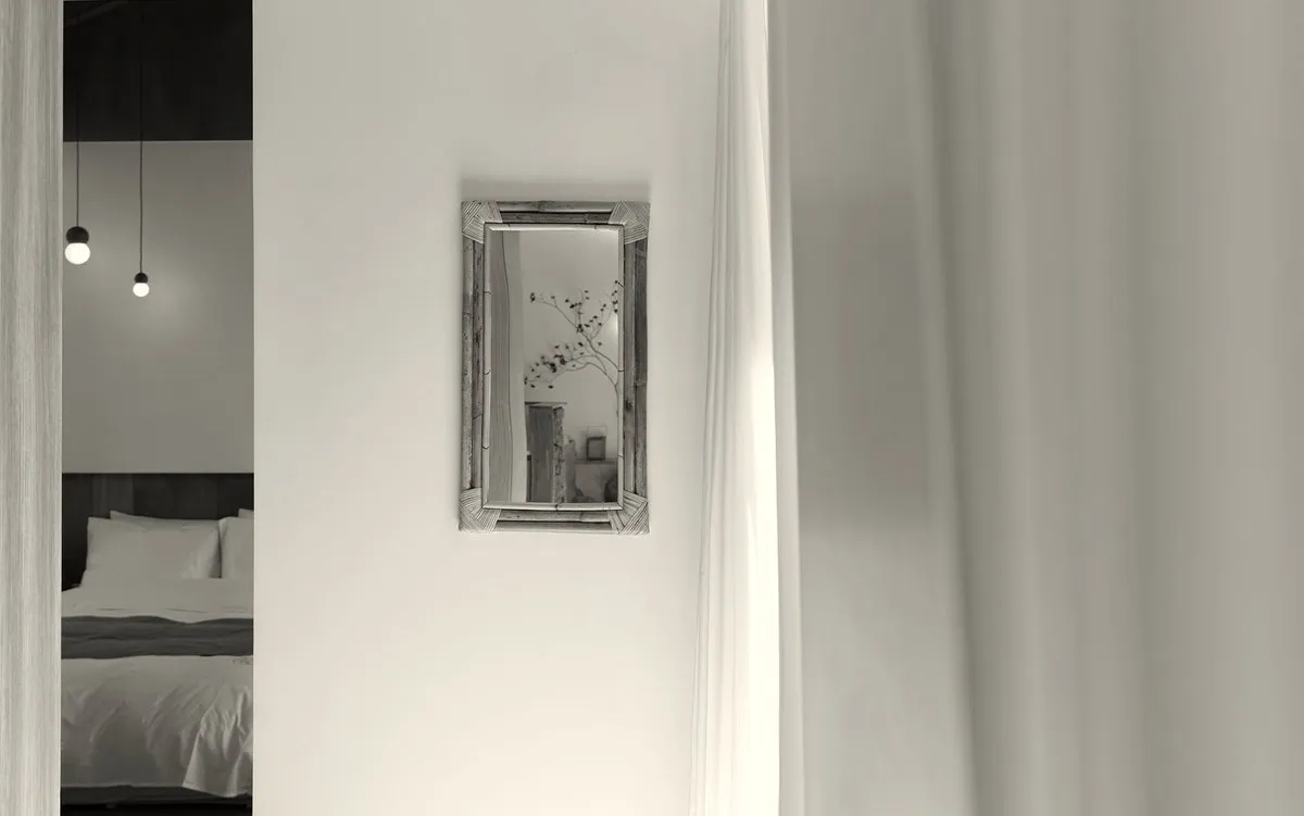 라탄 거울과 리넨 커튼이 있는 복도